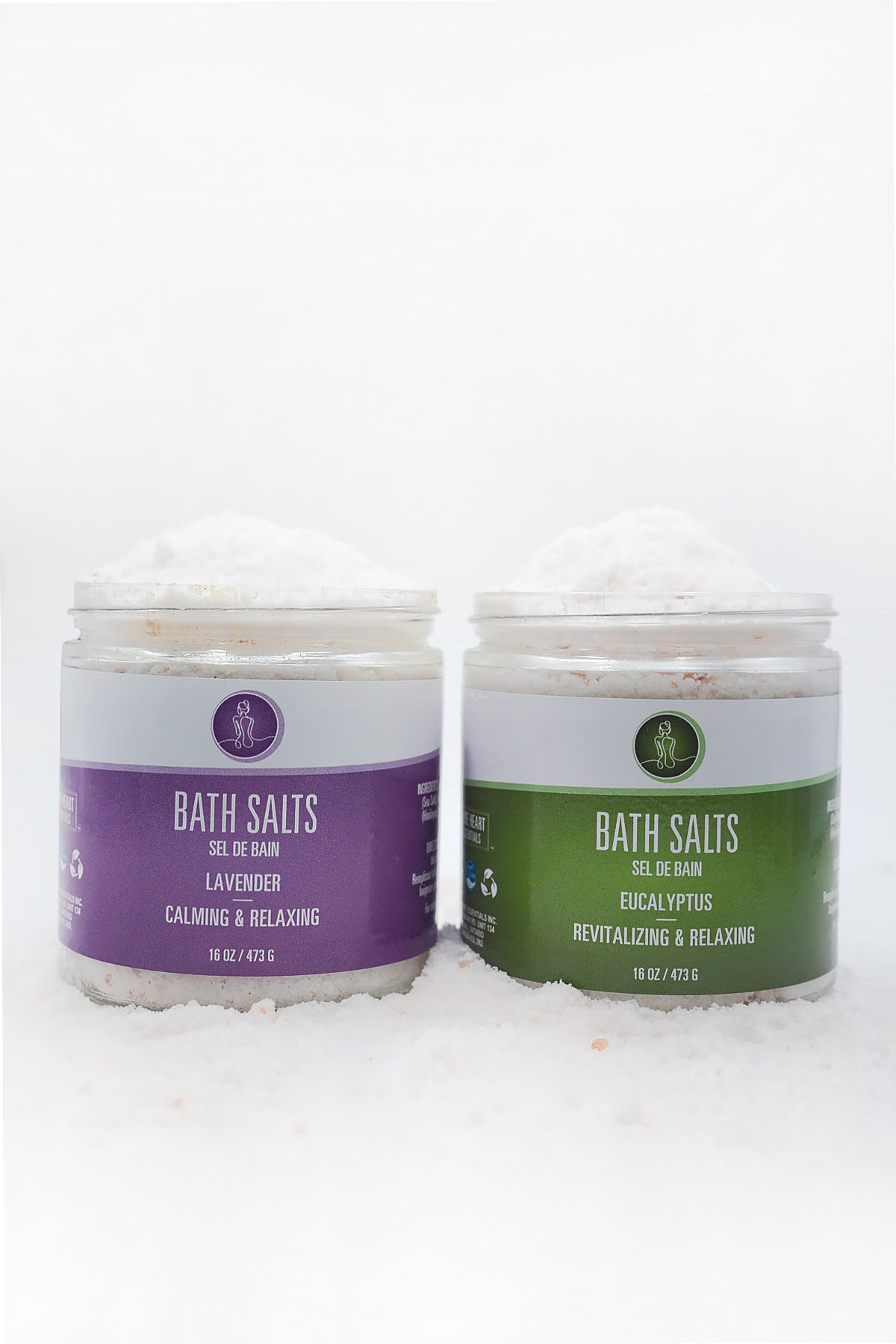 Two jars of bath salts with purple and green labels on a white background