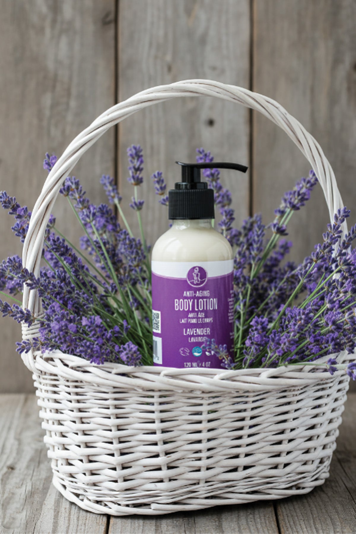 Basket with lavender and a bottle of body lotion on a wooden surface