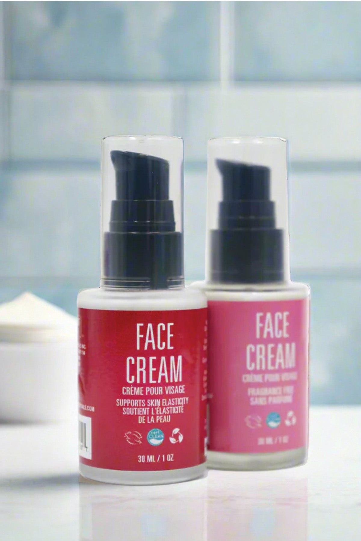 Two bottles of face cream with red labels on a blurred bathroom background