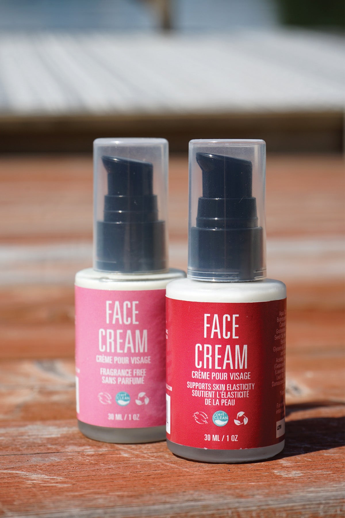 Two bottles of face cream on a wooden surface with a blurred background