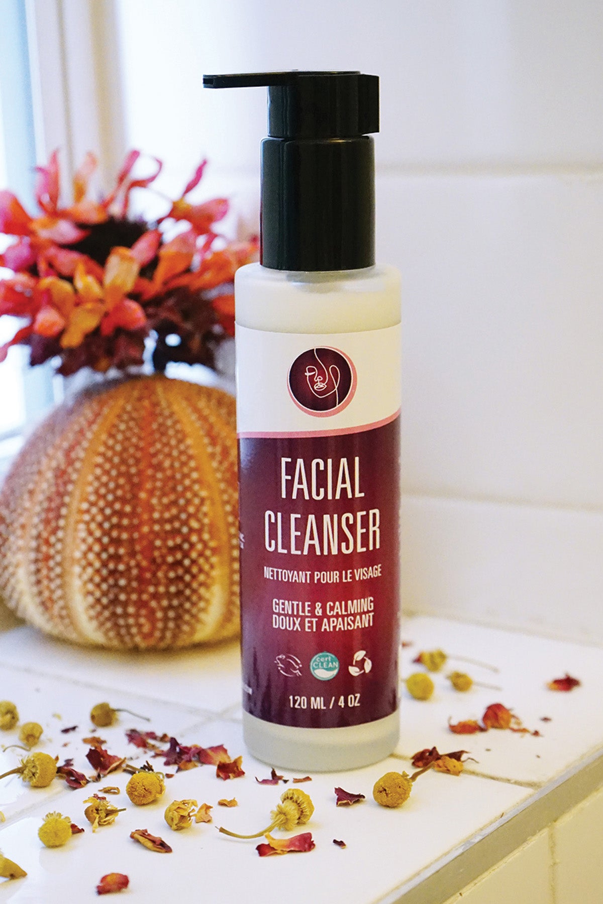 Facial cleanser bottle on a bathroom counter with decorative elements