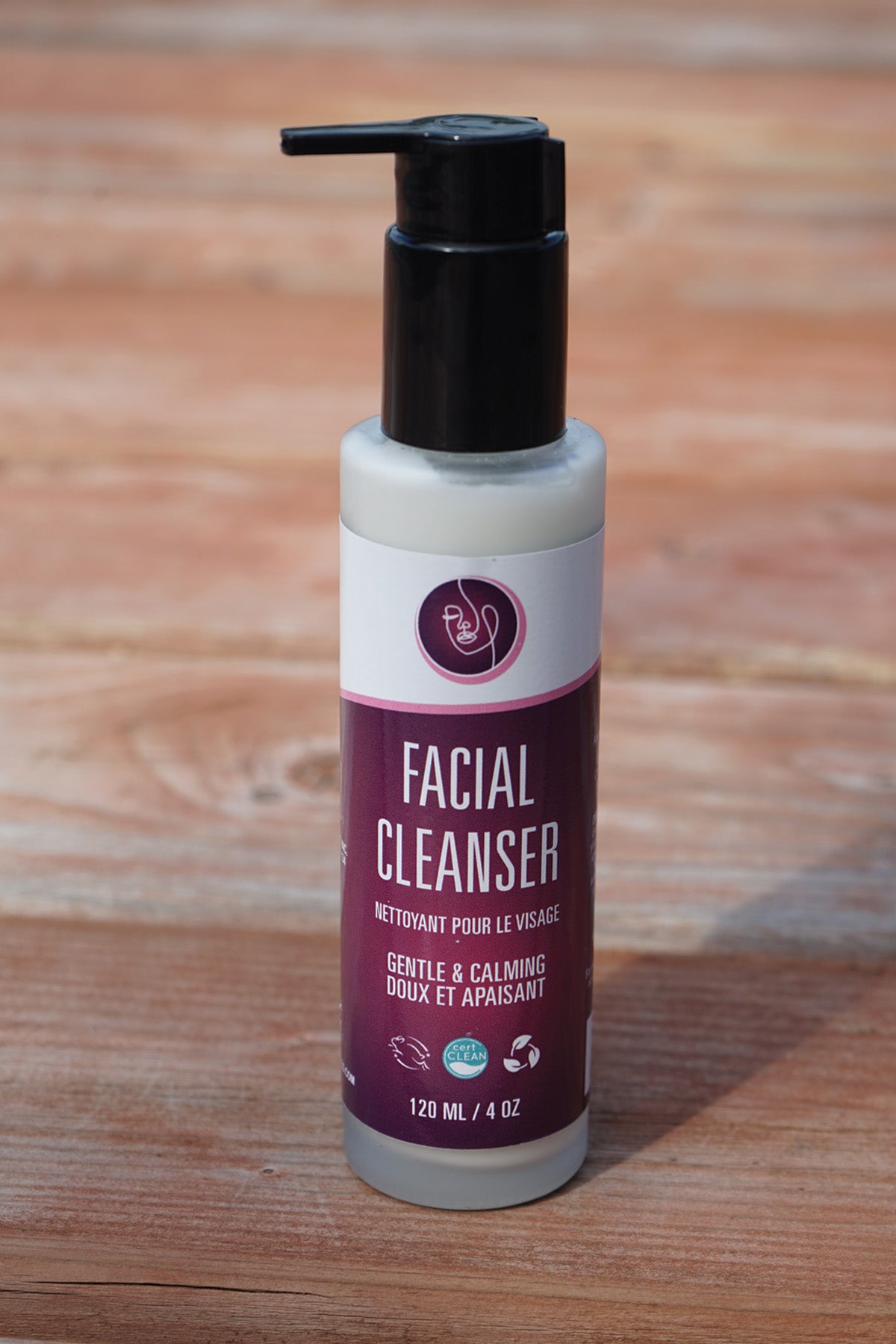 Facial cleanser bottle with pump on a wooden surface