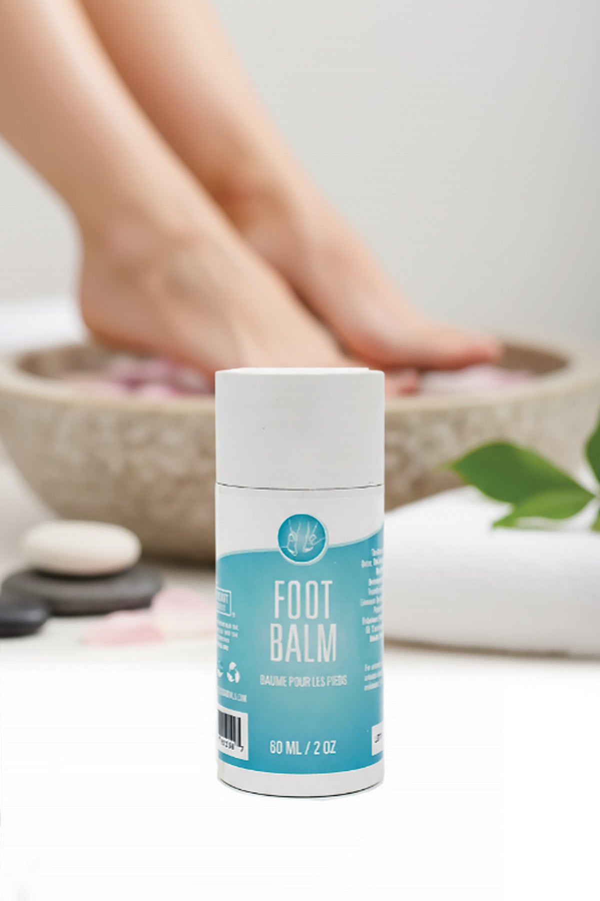 Foot balm container with a blurred background of feet and a bowl.
