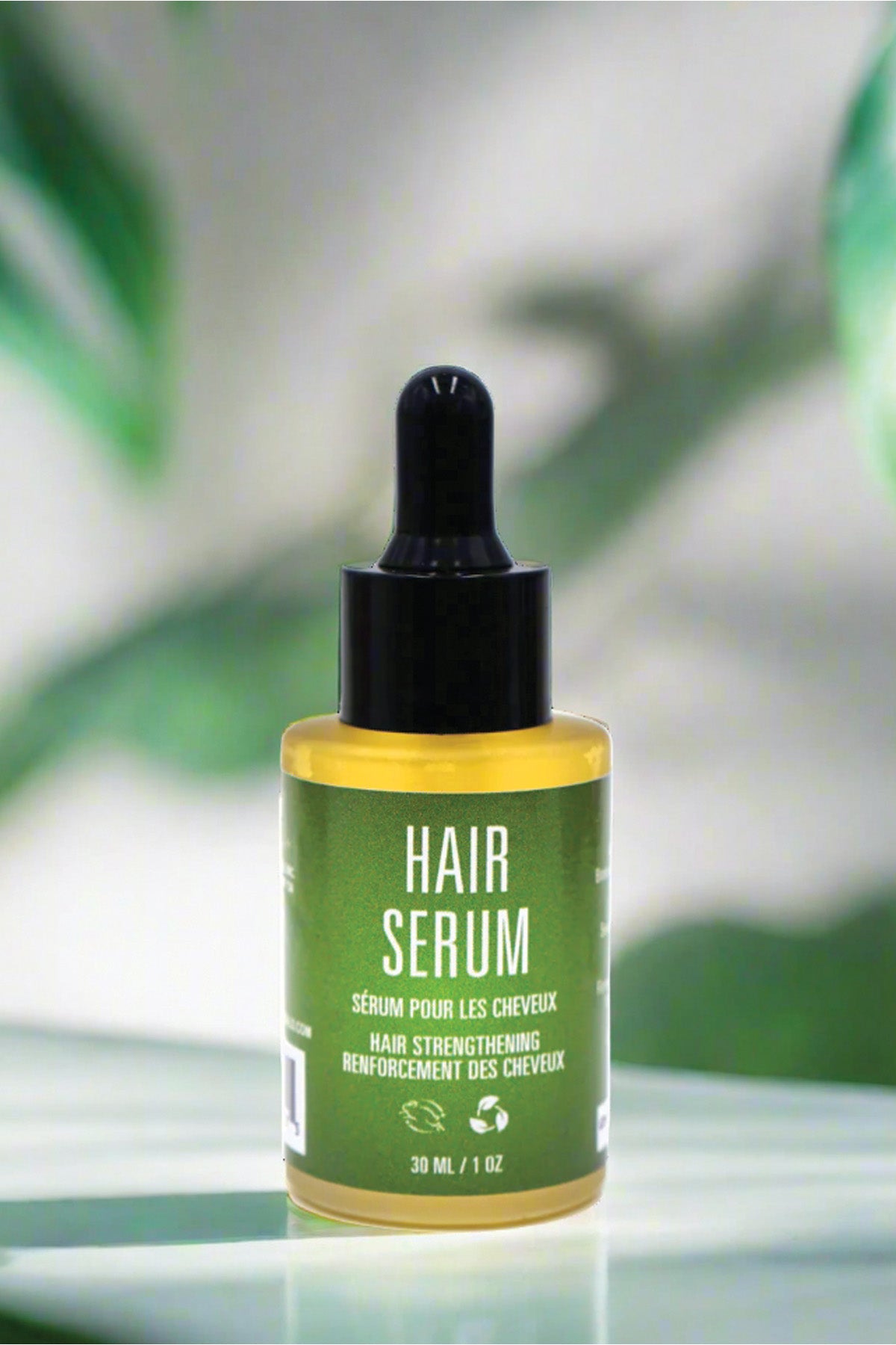 Hair serum bottle with green label on a blurred natural background