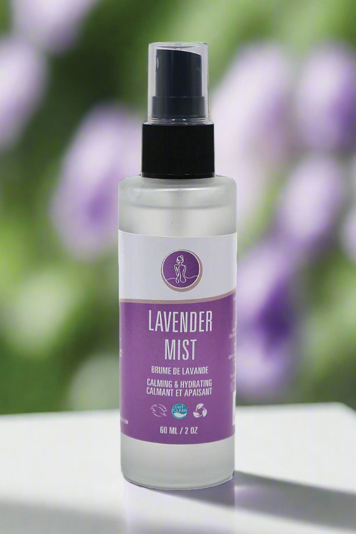 Lavender mist spray bottle with a purple label on a blurred natural background