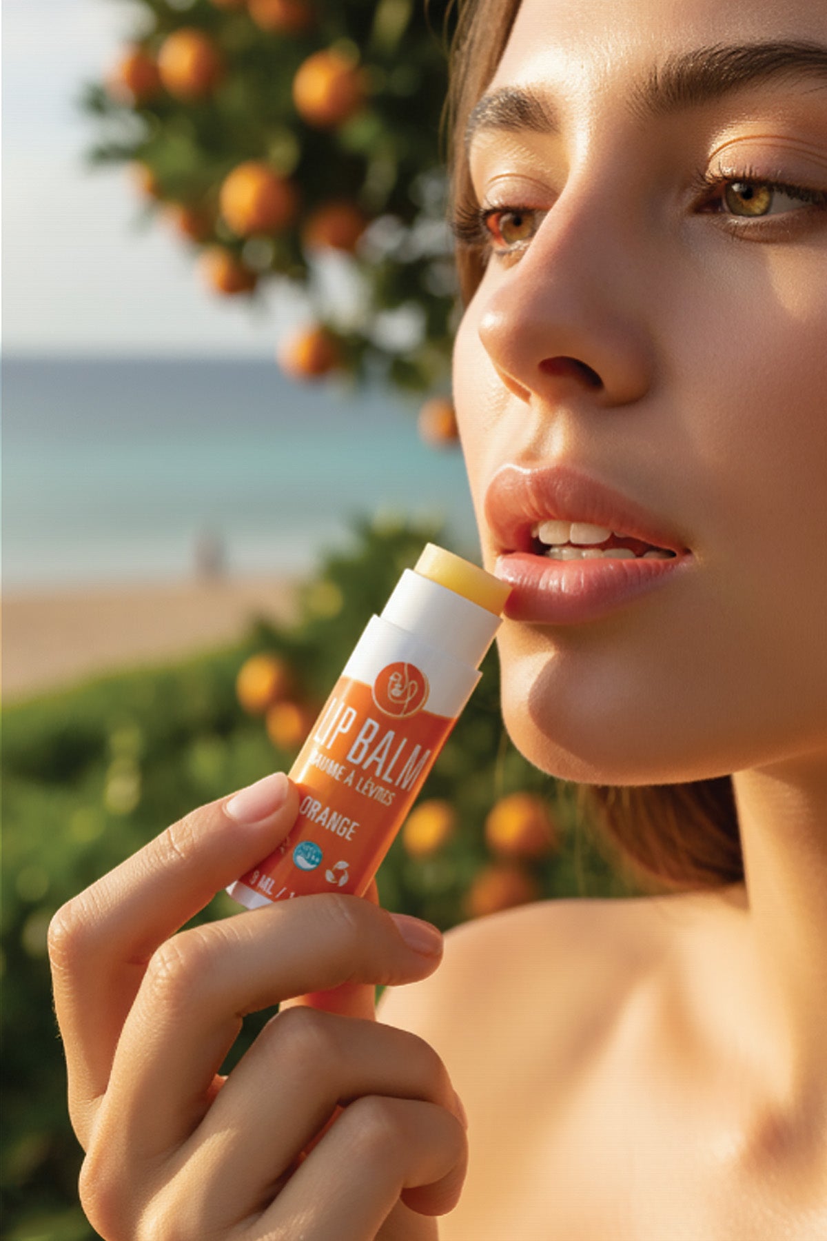 Woman applying lip balm with a beach and orange trees in the background