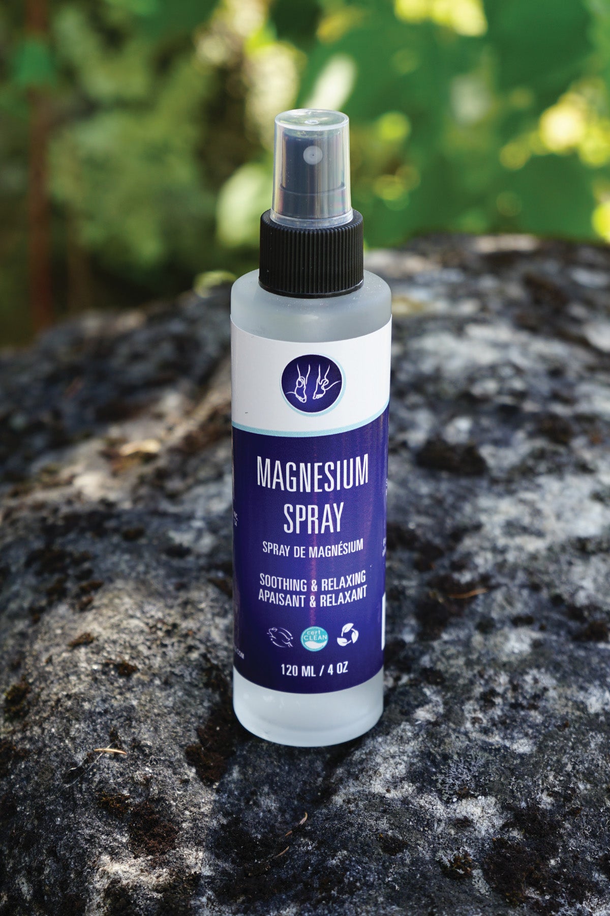 Bottle of magnesium spray on a rock with a blurred green background
