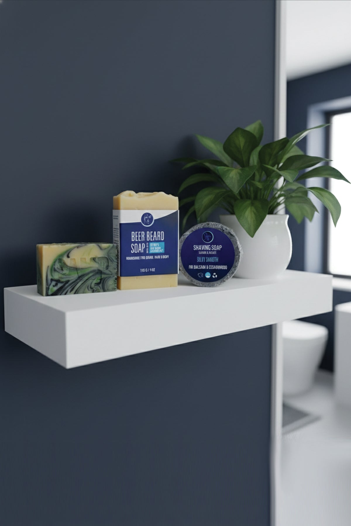 White shelf with soaps and a plant against a dark blue wall in a bathroom.