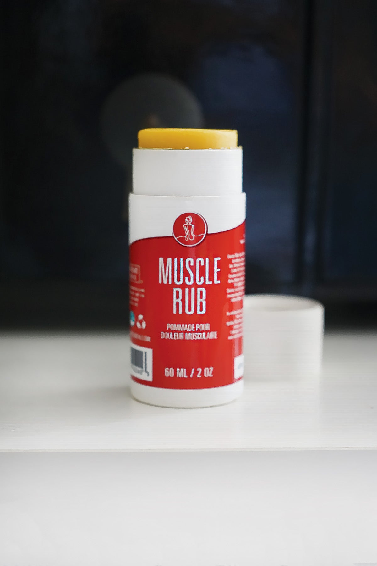 Tube of muscle rub on a white surface with a dark background