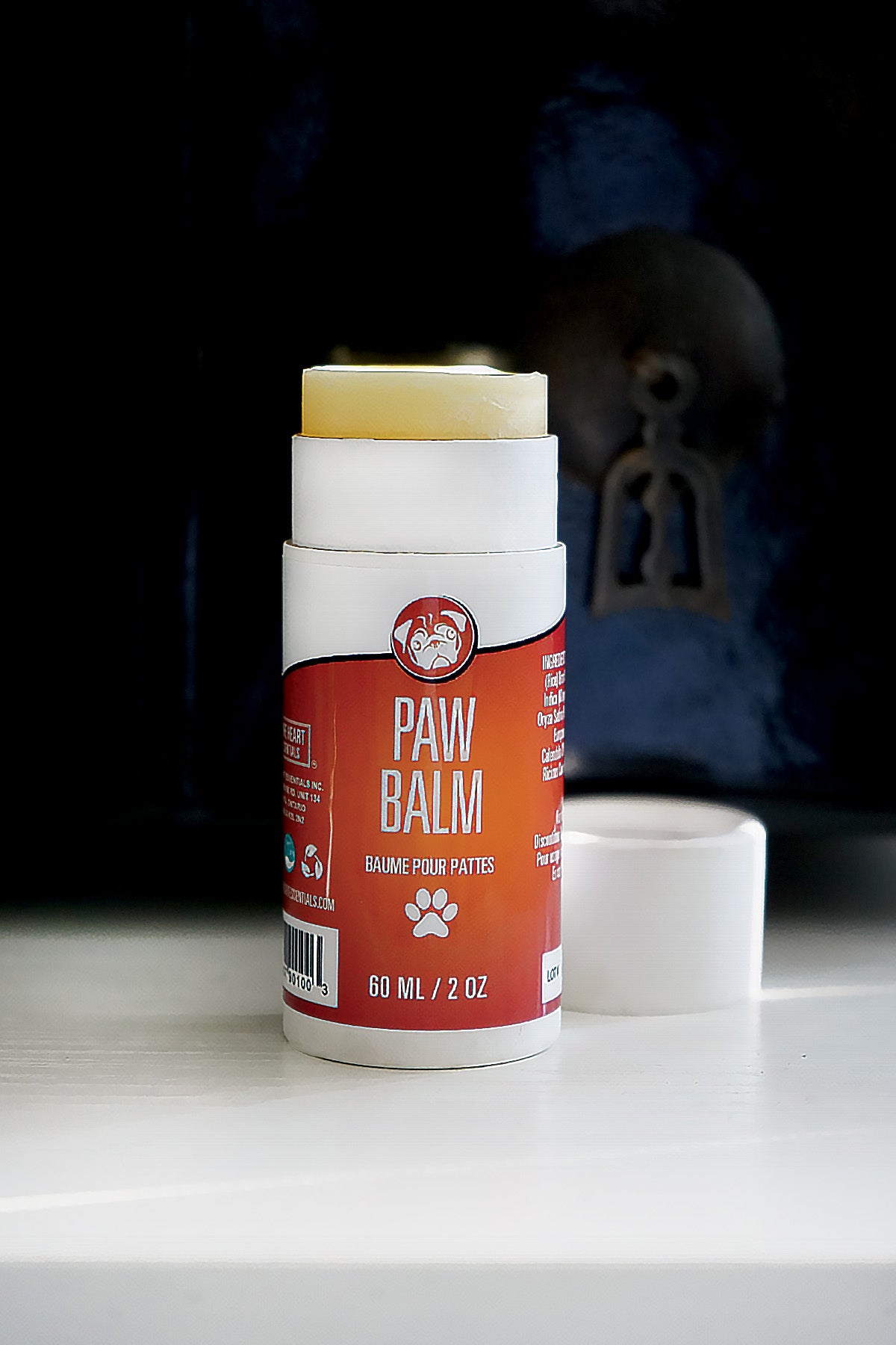 Paw balm stick with red label on a white surface