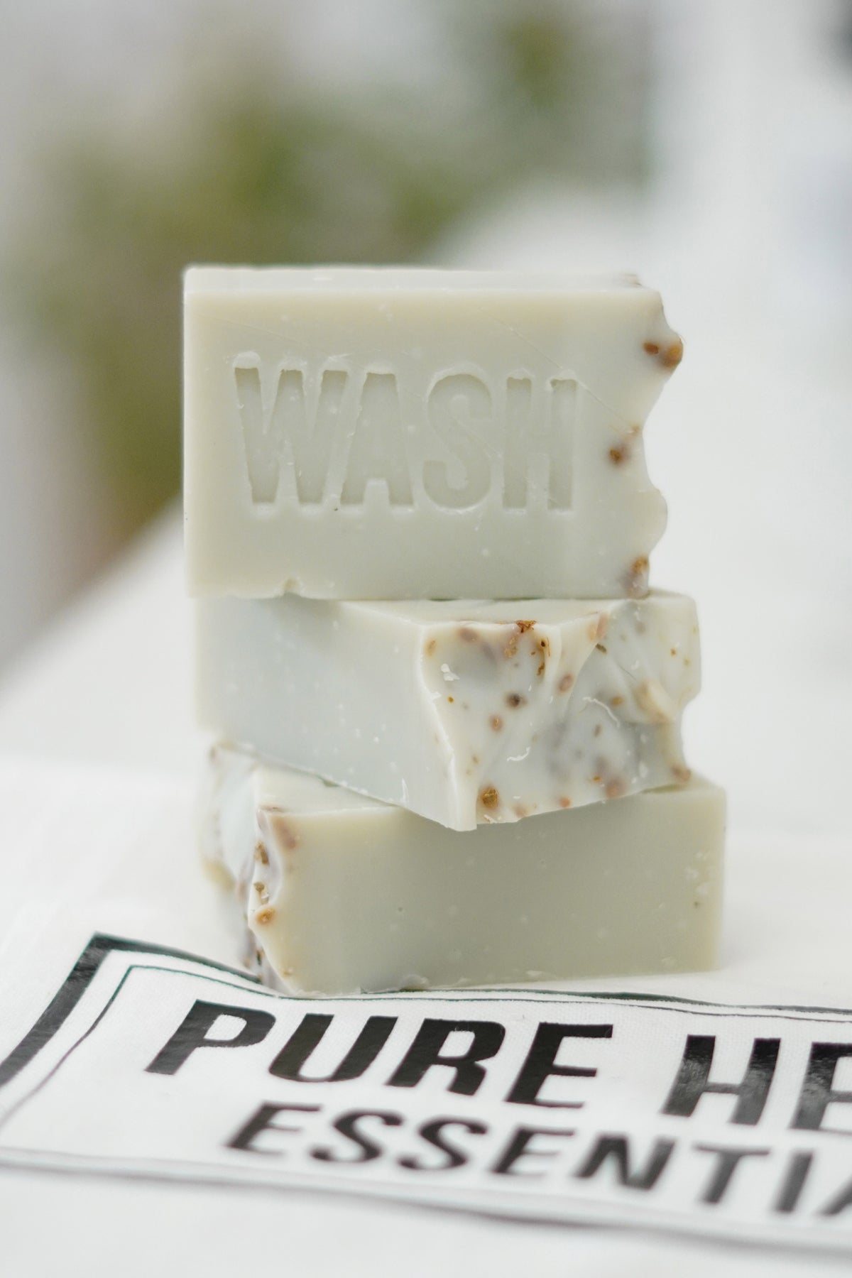 Three bars of soap stacked on a white surface with 'PURE HEART ESSENTIALS' branding.
