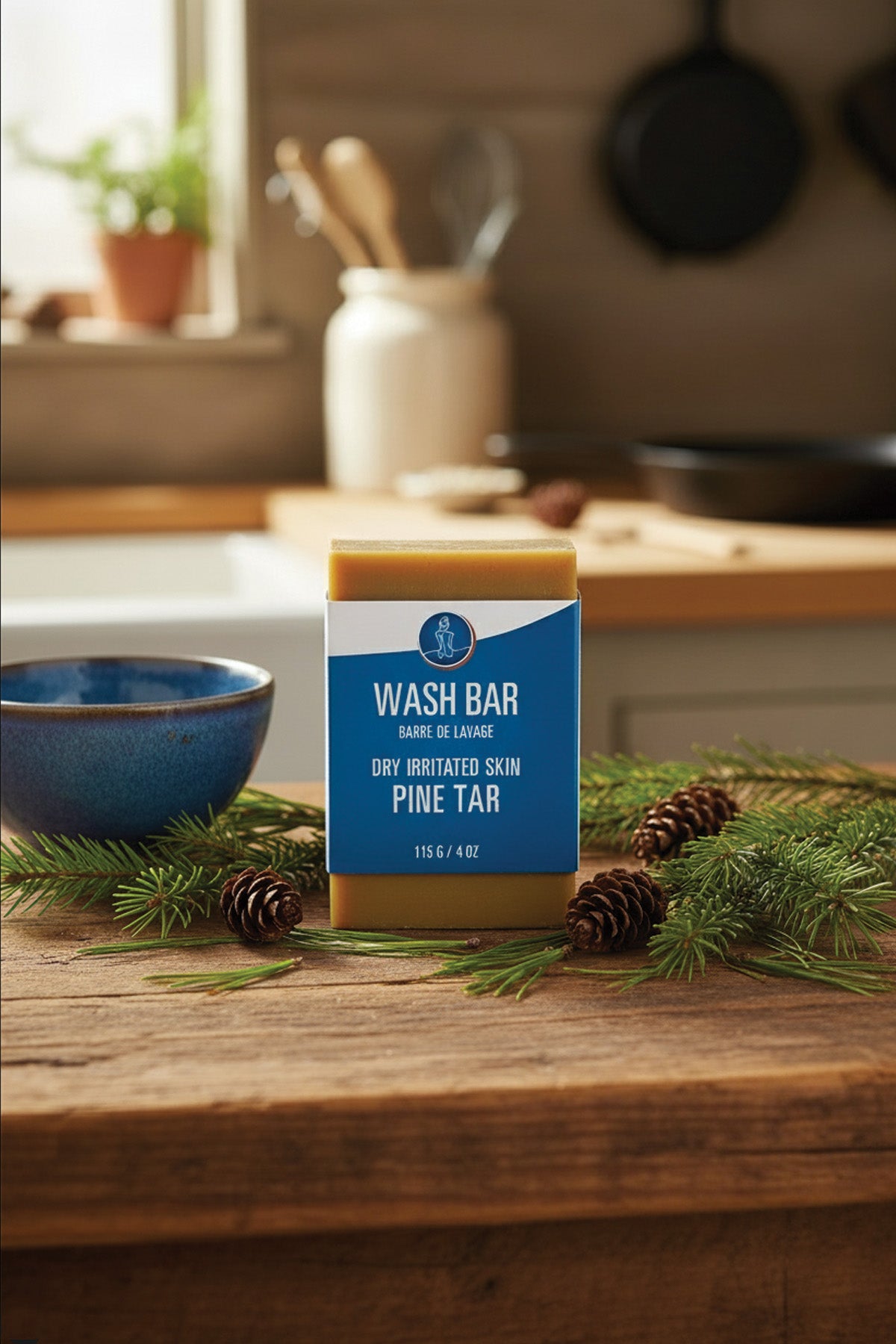 Bar of soap with a blue label on a wooden surface with pine branches and cones.