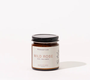 Candle jar labeled 'Wild Rose' by Wildwood Creek on a white background
